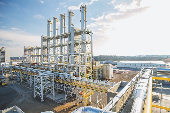 Several tall towers surrounded by scaffolding used to distill trichlorosilane gas.