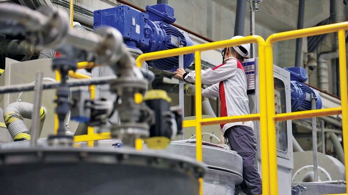 An employee works on machinery at an Aleees factory producing lithium iron phosphate.