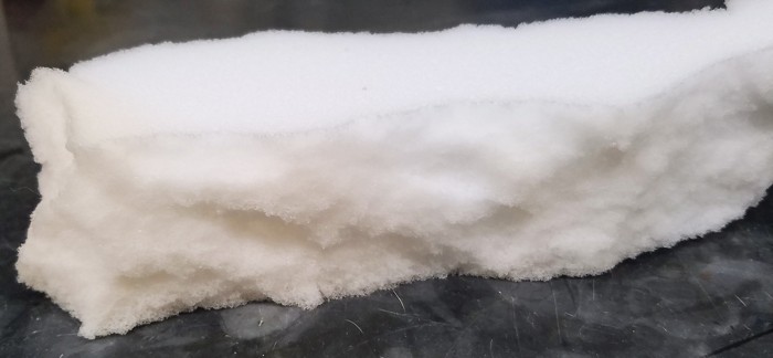 A chunk of white polyurethane foam sits on a table. 09817-scicon8-foam.jpg