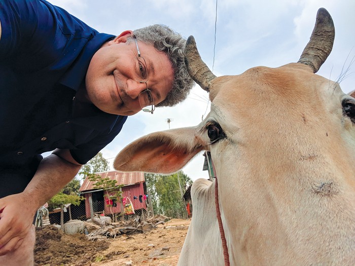 Photo d'un chercheur posant avec une vache. 09825-feature1-ben.jpg