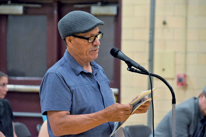 Photo of a man speaking at a public meeting