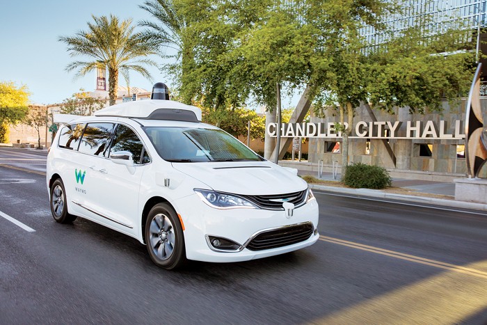 A white minivan with a device on top. 09841-cover-waymo.jpg